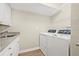 Well-lit laundry room features a sink, granite countertop, cabinets, and front load washer and dryer at 352 La Hacienda Dr, Indian Rocks Beach, FL 33785