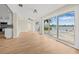 Bright living area featuring light wood floors, neutral walls, kitchen and sliding glass doors with water views at 352 La Hacienda Dr, Indian Rocks Beach, FL 33785