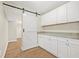 Butler's pantry with granite countertops, white cabinets, and a barn door to the hallway at 352 La Hacienda Dr, Indian Rocks Beach, FL 33785