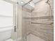 Walk-in shower with glass door features stylish tile with an accent row and a supportive grab bar at 352 La Hacienda Dr, Indian Rocks Beach, FL 33785