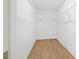 Empty walk-in closet with wood floors and white shelving units for optimal storage solutions at 352 La Hacienda Dr, Indian Rocks Beach, FL 33785