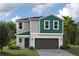 Charming two-story home with gray siding, teal accents, and a two-car garage on a lush green lawn at 37147 Sagemoor Dr, Zephyrhills, FL 33541