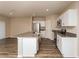 Open-concept kitchen with island, stainless steel appliances, and hardwood flooring at 37147 Sagemoor Dr, Zephyrhills, FL 33541