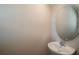 Cozy powder room featuring a pedestal sink, oval mirror, and neutral paint at 37147 Sagemoor Dr, Zephyrhills, FL 33541