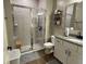 Bathroom with glass-enclosed shower, granite countertop vanity, and wood look flooring at 3895 Tate Ct, North Port, FL 34288