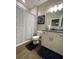 Cozy bathroom with a vanity, a toilet, tiled wood-look floor, and a shower with a curtain at 3895 Tate Ct, North Port, FL 34288