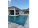Backyard pool and covered patio with outdoor seating, ideal for entertaining at 3895 Tate Ct, North Port, FL 34288