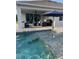 Outdoor pool with a partially submerged sun shelf and covered patio area at 3895 Tate Ct, North Port, FL 34288