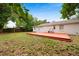 The backyard features a wooden deck attached to the house with a white exterior at 3906 W Rogers Ave, Tampa, FL 33611