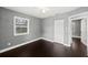 This bedroom features dark wood floors, a ceiling fan, and a bright window overlooking the backyard at 3906 W Rogers Ave, Tampa, FL 33611