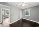This bedroom features dark wood floors, a ceiling fan, a closet, and a bright window at 3906 W Rogers Ave, Tampa, FL 33611