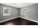 Bedroom features dark wood floors, neutral gray paint and windows with shutters at 3906 W Rogers Ave, Tampa, FL 33611