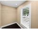 Walk-in closet with a wire rack shelf, dark wood floors, white trim, and a window with shutters at 3906 W Rogers Ave, Tampa, FL 33611