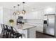 Modern kitchen featuring a large island, pendant lighting, white cabinets, and stainless steel appliances at 3906 W Rogers Ave, Tampa, FL 33611