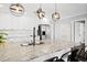 Kitchen features marble countertops, modern lighting, stainless appliances, and subway tile backsplash at 3906 W Rogers Ave, Tampa, FL 33611