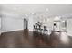 Open concept living space with modern lighting, dark hardwood floors, and a seamless flow into the kitchen at 3906 W Rogers Ave, Tampa, FL 33611