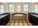 Luxurious bathroom featuring a soaking tub, dual vanities, and bay windows with shutters at 4313 W Vasconia St, Tampa, FL 33629