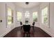 Bright dining room featuring hardwood floors, wainscoting, many windows, and a modern glass dining table at 4313 W Vasconia St, Tampa, FL 33629