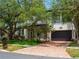 Elegant two-story home with a brick driveway and mature trees enhancing its curb appeal at 4313 W Vasconia St, Tampa, FL 33629