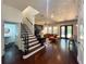 Open-concept living space featuring hardwood floors, staircase access, a comfortable couch, and outdoor views at 4313 W Vasconia St, Tampa, FL 33629