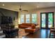 Spacious living room boasts hardwood floors, a ceiling fan, and a stylish leather couch near the french doors at 4313 W Vasconia St, Tampa, FL 33629