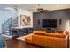 Bright living room featuring hardwood floors, comfortable seating, a ceiling fan, and a wall-mounted television at 4313 W Vasconia St, Tampa, FL 33629