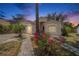 Charming single-story home at dusk featuring a well-manicured lawn and vibrant bougainvillea bushes at 4514 Arizona Sun Ct, Valrico, FL 33594
