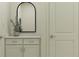 Neutral bathroom featuring a black framed arched mirror, granite countertop and white cabinet at 4752 Southern Valley Loop, Brooksville, FL 34601