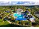 Aerial view of the community pool with palm trees, lounge chairs, and sun umbrellas at 4752 Southern Valley Loop, Brooksville, FL 34601