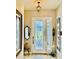 Elegant entryway with stylish decor, including a decorative glass door and sophisticated light fixture at 5103 98Th E Ave, Parrish, FL 34219