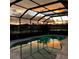 Enclosed pool reflecting the colorful sunset and water's reflection at 5103 98Th E Ave, Parrish, FL 34219