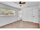 Bright bedroom with wood-look flooring, a ceiling fan, and ample natural light from the large window at 603 Amana Ave, Brandon, FL 33510
