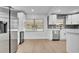 Open kitchen with stainless appliances, modern cabinetry, and views to the outdoor space through the windows at 603 Amana Ave, Brandon, FL 33510