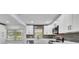 Bright kitchen with white cabinets, stainless appliances, gray backsplash, and natural light at 603 Amana Ave, Brandon, FL 33510