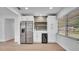 Modern kitchen with bar seating, stainless refrigerator, white cabinets, open shelving, and drink refrigerator at 603 Amana Ave, Brandon, FL 33510