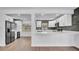 Bright and open kitchen with stainless refrigerator, open shelving, bar seating, and a wine refrigerator at 603 Amana Ave, Brandon, FL 33510