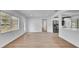 Bright open-concept living room featuring wood-look floors, white walls, and seamless transition to the modern kitchen at 603 Amana Ave, Brandon, FL 33510