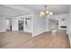 Open-concept living space with modern lighting, wood-look floors, and view of the connected kitchen at 603 Amana Ave, Brandon, FL 33510