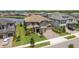 Aerial view of the house showcasing lush landscaping, a three car garage, and nearby lake at 6109 Marsh Trail Dr, Odessa, FL 33556
