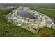 An aerial view showcases the neighborhood around a lake with mature trees surrounding the area at 6109 Marsh Trail Dr, Odessa, FL 33556