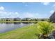 Backyard view of the lakefront property with lush lawn and palm trees at 6109 Marsh Trail Dr, Odessa, FL 33556