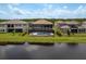 Backyard view of a home with a screened pool facing a lake and neighboring properties at 6109 Marsh Trail Dr, Odessa, FL 33556