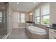 Relaxing bathroom with a soaking tub, separate shower, and elegant fixtures with large windows for natural light at 6109 Marsh Trail Dr, Odessa, FL 33556