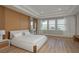 Stylish bedroom features a wood accent wall, tray ceiling, and large windows with natural light at 6109 Marsh Trail Dr, Odessa, FL 33556