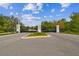 Community entrance gate featuring decorative pillars, secure access, and manicured landscaping at 6109 Marsh Trail Dr, Odessa, FL 33556