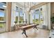 Well-lit game room with a shuffleboard table, seating, and large windows with picturesque views at 6109 Marsh Trail Dr, Odessa, FL 33556
