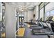 Bright gym featuring multiple machines, treadmills, ceiling fan, decorative ceiling and large window at 6109 Marsh Trail Dr, Odessa, FL 33556