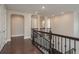 Bright hallway features dark wood floors, wrought iron bannister, and arched doorways leading to other rooms at 6109 Marsh Trail Dr, Odessa, FL 33556
