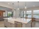 Bright kitchen features a large island with a farmhouse sink, stainless steel appliances, and stunning lake views at 6109 Marsh Trail Dr, Odessa, FL 33556
