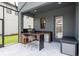 Outdoor kitchen with stainless steel grill, mini-fridge, bar, and comfortable seating under a covered patio at 6109 Marsh Trail Dr, Odessa, FL 33556